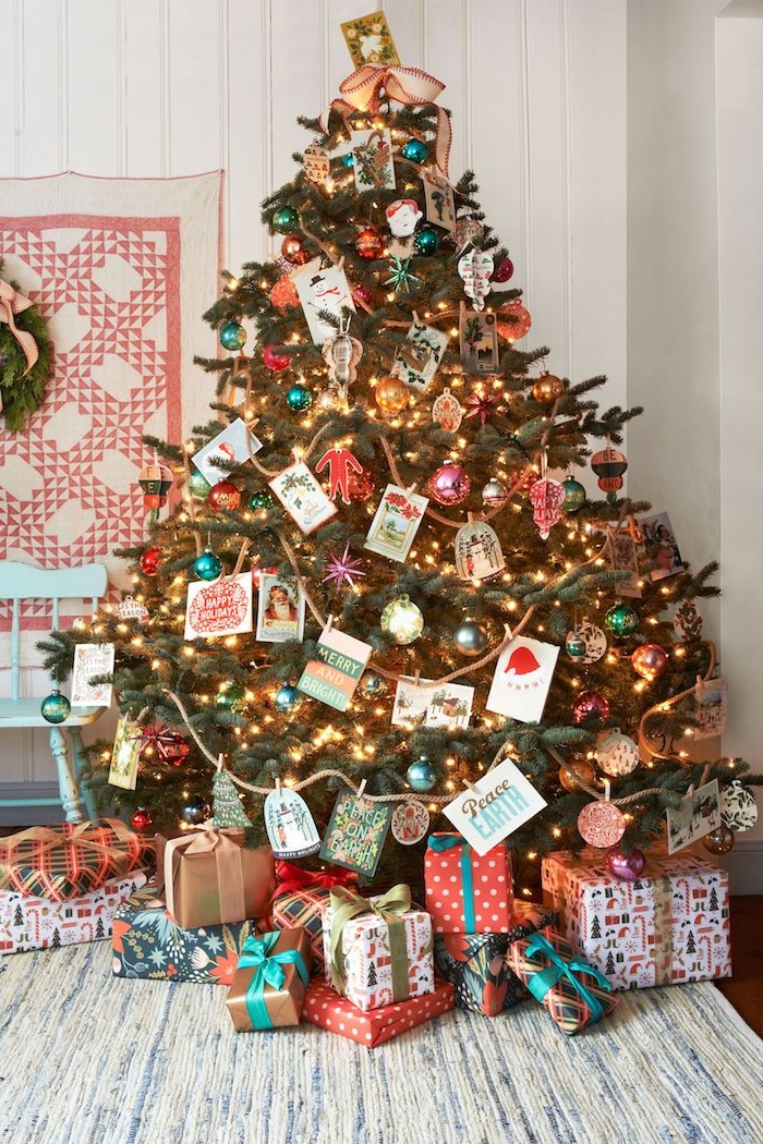 Großer Weihnachtsbaum geschmückt mit bunten Christbaumkugeln, Weihnachtskarten und Lichterkette