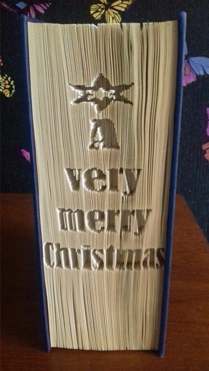 Eine Aufschrift A very merry Christmas, was auf Deutsch sagt, Fröhliche Weihnachten, gefaltete Bücher