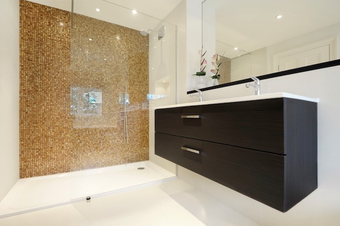 schwarzes waschbecken und ein spiegelschrank im badezimmer mit braunen und weißen fliesen
