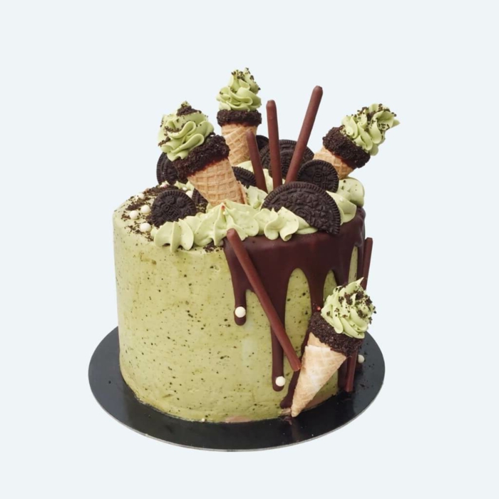 grüne Creme deckt dieser Kuchen, Oreo Keks Kuchen Rezept, Schokoladen, Bonbons und Waffeln als Dekoration