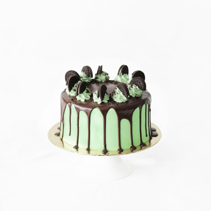 Oreo Keks Kuchen Rezept, Schokoladenglasur, halbe Kekse als Dekoration, eine grüne Torte