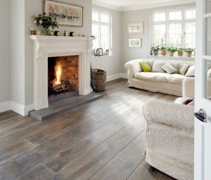 ein gemütliches Wohnzimmer Weiß Grau, ein Kamin mit Feuer, weiße Wohnzimmermöbel