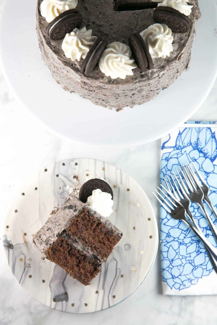 ein Stück Oreo Torte, zwei Schokoladenböden und Schokolade Creme dazwischen, weiße Dekoration