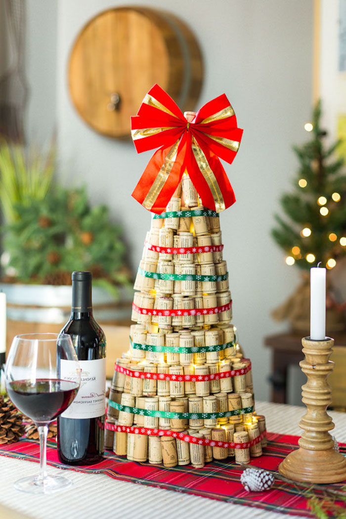 Selbstgemachter Weihnachtsbaum aus Weinkorken, geschmückt mit großer roter Schleife, Weinflasche und Weinglas 