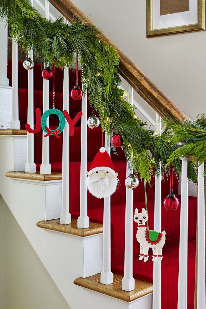 Die Treppe mit Tannengirlande dekorieren, silberne und rote Christbaumkugeln, Weihnachtsmann und Lama 