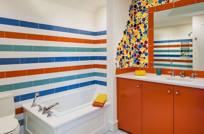 kleine weiße badewanne mit wänden aus bunten fliesen, ein oranger badezimmer spiegelschrank, badezimmer modern