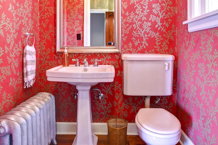weißes waschbecken und ein spiegel im badezimmer mit roten wänden und einem weißen fenster