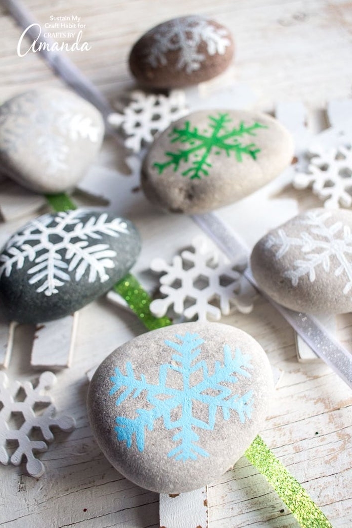 Steine bemalen, Schneeflocken auf Steine zeichnen, coole Ideen für winterliche Dekoration 