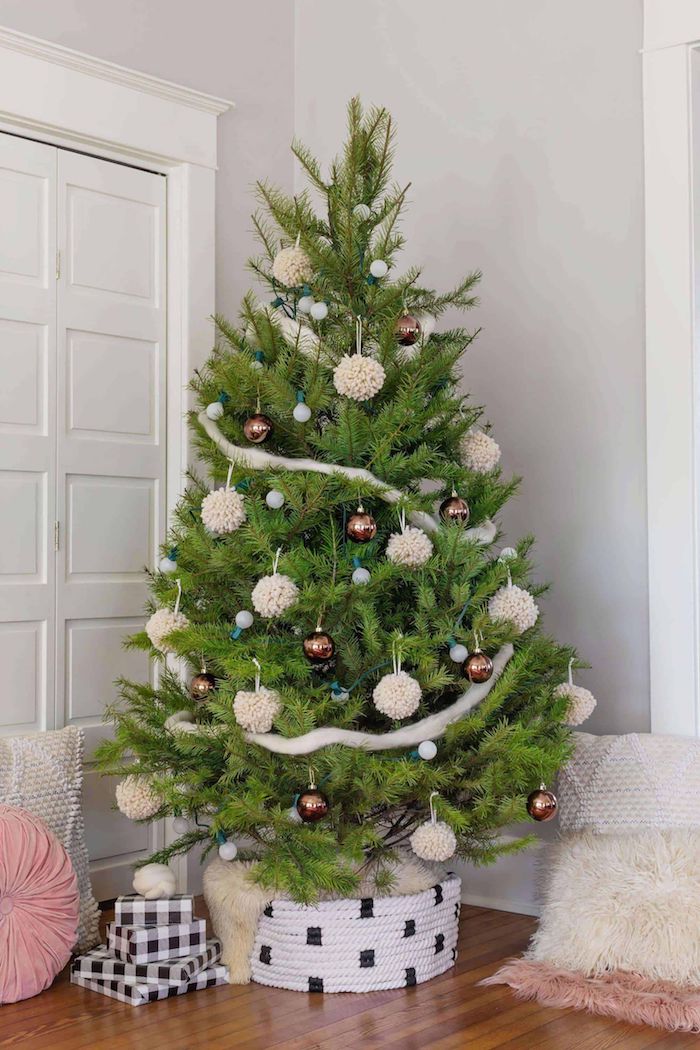 Echter Weihnachtsbaum geschmückt mit Christbaumkugeln und Girlanden, große weiße Pompons 