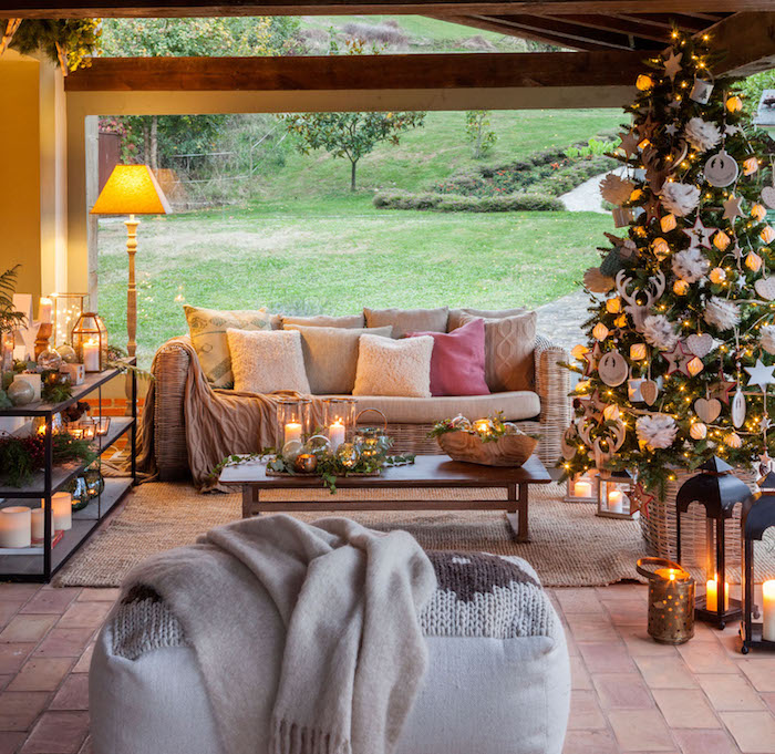 Prachtvoll geschmückter Weihnachtsbaum, viele Dekokissen auf dem Sofa, Kerzen überall 