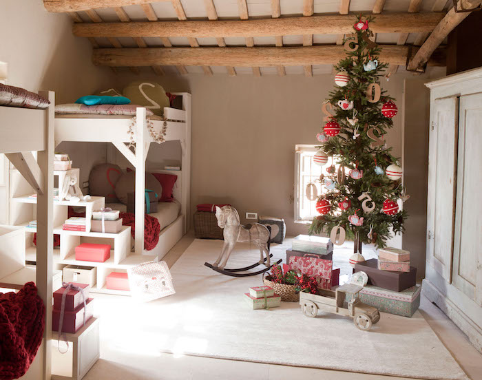 Landhaus Einrichtung, kleiner Weihnachtsbaum mit bunten Weihnachtskugeln, weiße Holzmöbel 