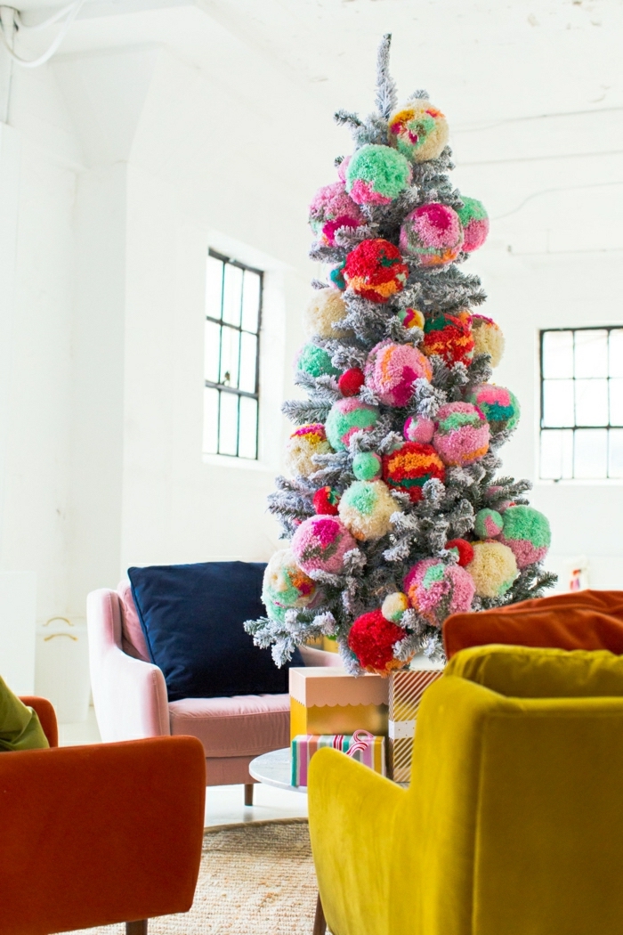 Weihnachtsbaum geschmückt mit großen bunten Pompons, Sofas in grellen Farben, Wandfarbe Weiß