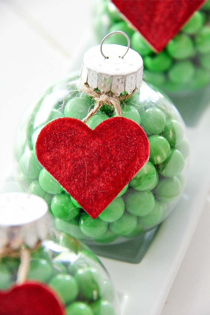 weihnachtsdeko basteln, grüne bonbons, rotes herz, transparente weihnachtskugel