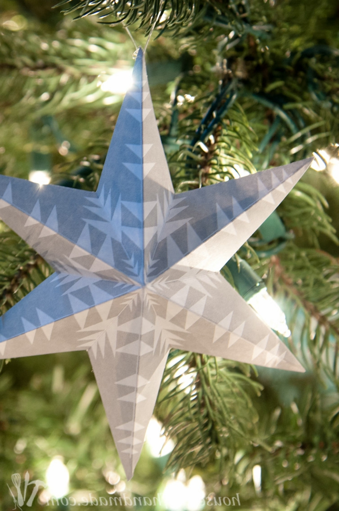 Papiersterne falten, ein grauer Stern mit Schneeflocken Muster verschönert den Weihnachtsbaum