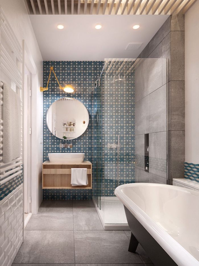 badezimmer mt freistehenden weißen badewanne und grauen boden und blauen wänden aus badezimmer fliesen