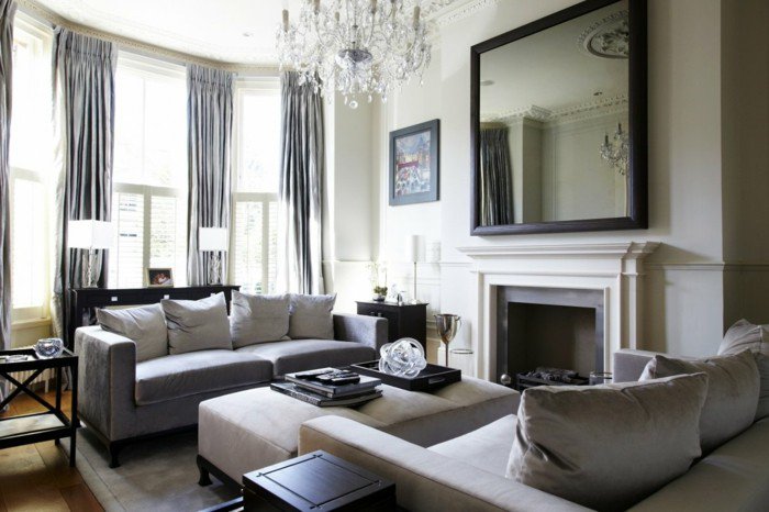 ein großer Spiegel, zwei Sofas, Kronleuchter aus Glas, Laminatboden, Wohnzimmer Weiß Grau