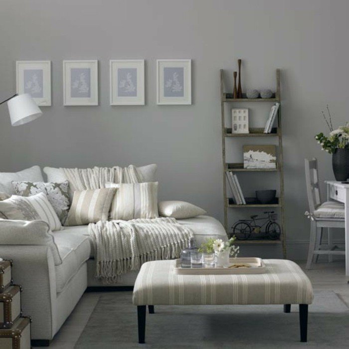 Wohnzimmer Weiß Grau, ein weißes Sofa, vier kleine Bilder, Leiter als Bücherregal, kleiner Couchtisch