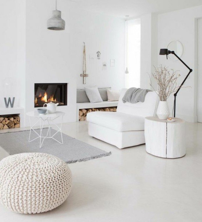ein grauer Teppich, weißer Abstelltisch, Kamin mit warmem Feuer, ein weißer Sessel, Wohnzimmer Weiß Grau
