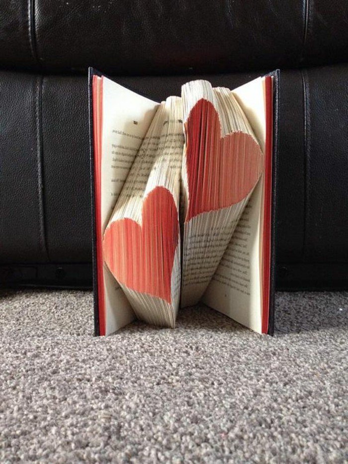 zwei Herzen in roter Farbe aus einem Buch mit roten Seiten, gefaltete Bücher zu Valentinstag