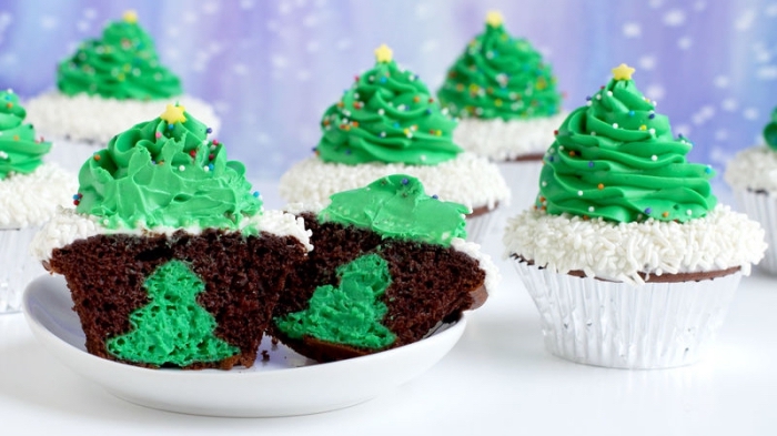 winterliche desserts, schokomuffins dekoriert mit weißer und grüner sahne, kleine weihanchtsbäume