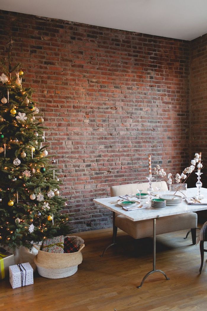 Minimalistische Einrichtung im Wohnzimmer, echter Weihnachtsbaum geschmückt mit bunten Christbaumkugeln 