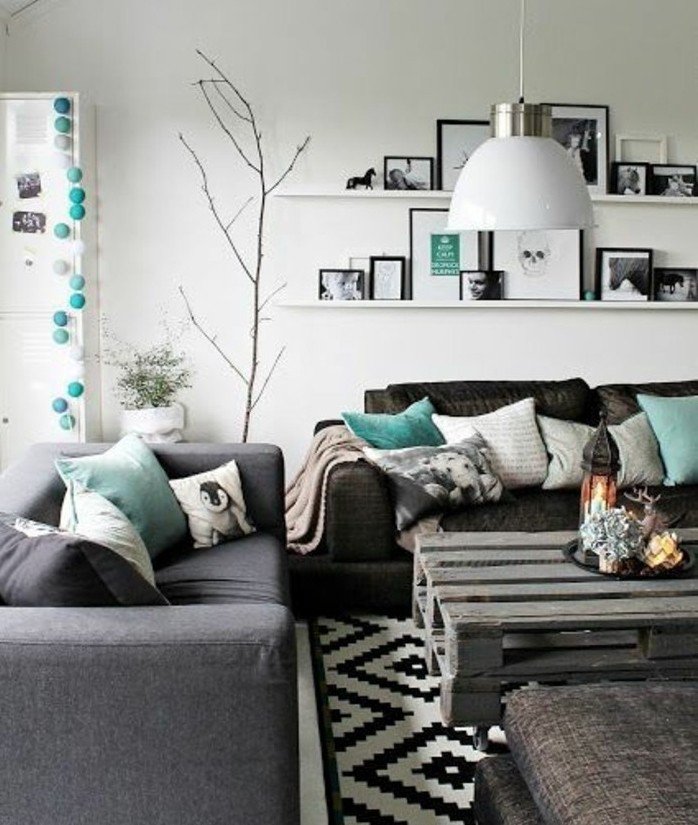 graues Sofa und schwarzes Sofa mit grünen Kissen, zwei Leistne mit vielen Bildern, Wohnzimmer Weiß Grau