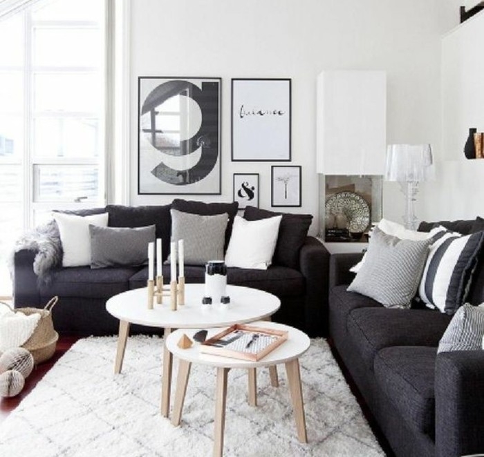 zwei schwarze Sofas, ein weißer Teppich, Wohnzimmer Weiß Grau, weiße Wandfarbe, schöne Bilder