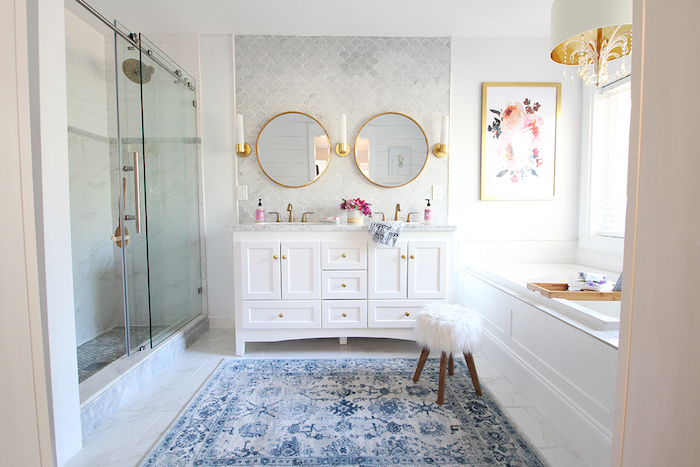 großer blauer teppich und ein kleiner weißer stuhl im badezimmer mit zwei spiegeln und badezimmer regalen, badezimmer mit weißen fenstern