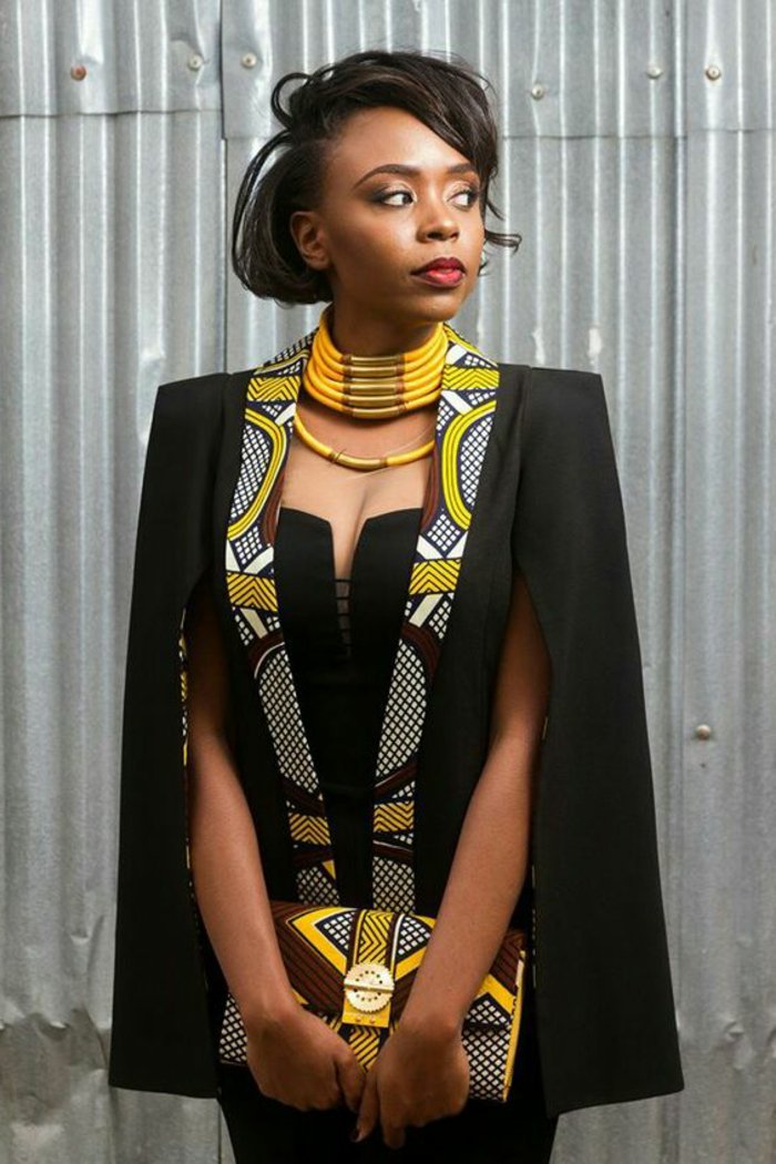kreative und moderne afrikanische muster zum entlehnen. eine frau fertig zum besonderen anlass, schwarzer eleganter stil mit bunten afro dekorationen, clutch