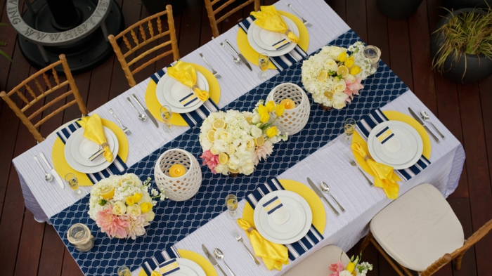 blauer Tischläufer, gelbe Untersilien, gelbe Servietten, weiße Blumen und Zitronen, Geburtstagsdeko 