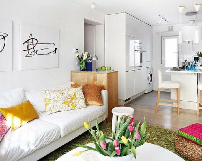Kleines Wohnzimmer einrichten, weißes Sofa, bunte Kissen, ein runder Stuhl, Vase mit Tulpen