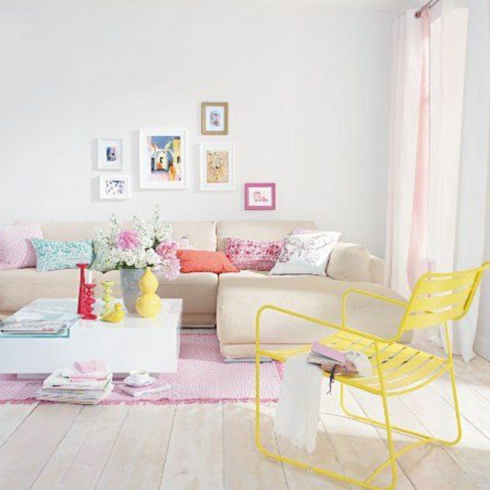 rosa Sofa, ein weißer Tisch mit gelben Vasen, ein gelber Stuhl, kleines Wohnzimmer einrichten