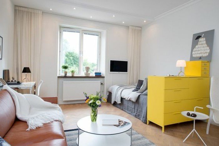 gelbe Regale, ein Ledersofa, ein runder Tisch, ein grauer Teppich, Einrichtungsideen Wohnzimmer