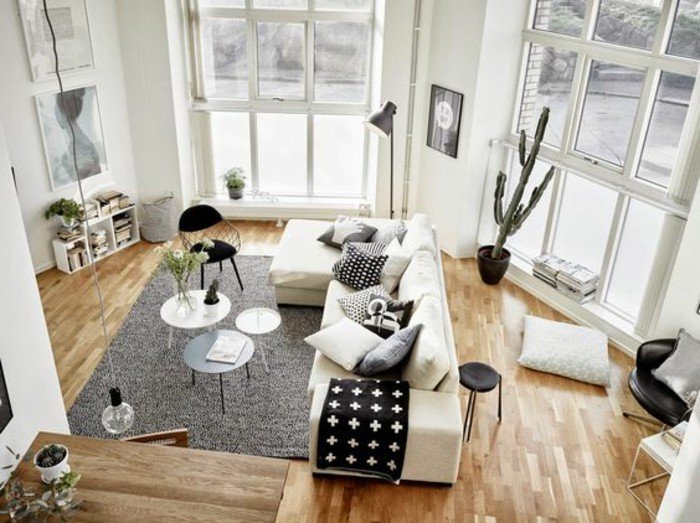 weißes Sofa mit schwarz weißen Kissen, drei runde Tischen, ein grauer Teppich, Einrichtungsideen Wohnzimmer