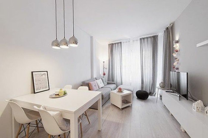 ein graues Sofa, ein weißes Regal, ein kleiner Tisch, schwarzer Hocker, Einrichtungsideen Wohnzimmer