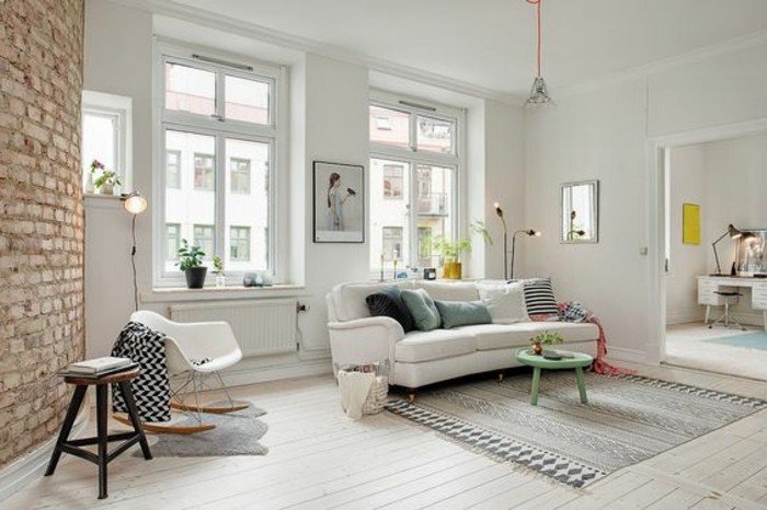 ein weißes Sofa, ein grauer Teppich, ein kleiner grünen runden Tisch, Wohnzimmer gestalten
