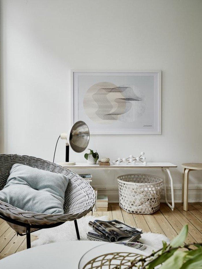 ein grauer Sessel, weiße Wände mit einem Bild, viele kleine Tische, Wohnzimmer gestalten