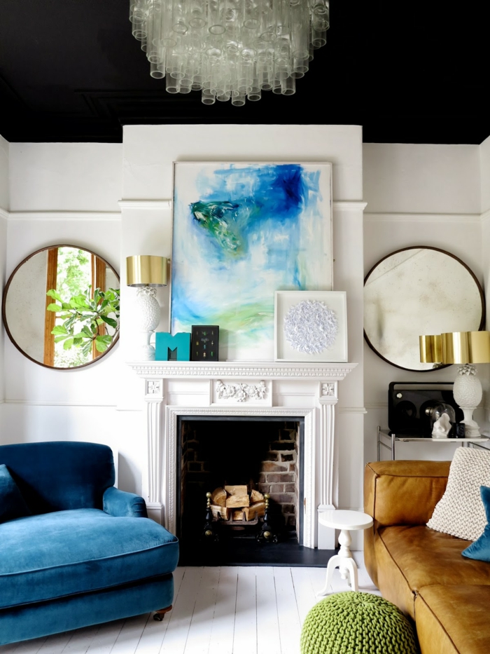 zwei runde Spiegel, symmetrische Einrichtung, ein blauer Sessel, Ledersofa, eine weiße Diele, Wohnzimmer Farben