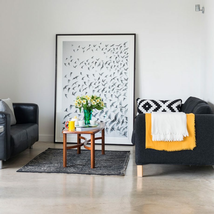 ein weißes Wandbild mit schwarzen Vögeln, zwei Sessel, ein schwarzer Teppich, ein kleiner Tisch, Wohnzimmer Ideen Wandgestaltung