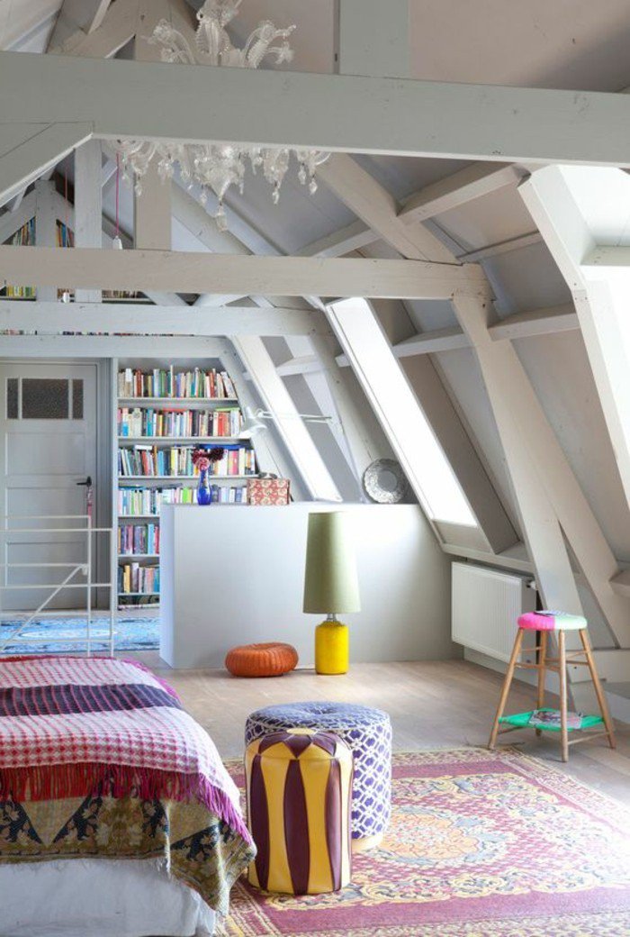 ein weißes Regal mit vielen Büchern, bunter Teppich, bunte Hocker, eine Dachgeschöss, kleines Wohnzimmer einrichten