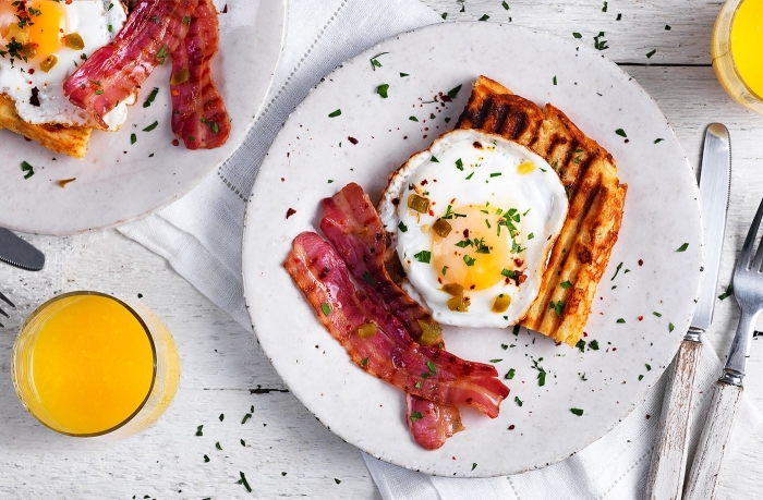 frühstück rezepte, eier mit bacon und gegrillter brotscheibe, glas mit orangensaft
