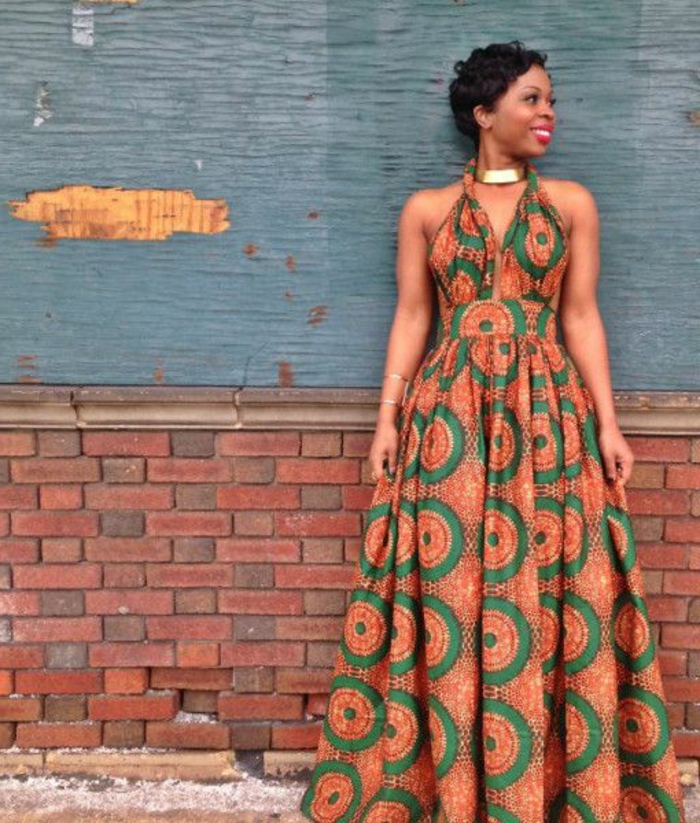 afrikanische mode zum inspirieren, eine lächelnde frau an blauem und robusten hintergrund, orange und grün kleidmuster