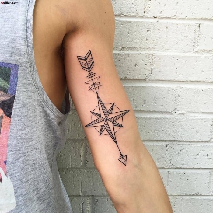 mann mit kompass tattoo am oberarm, geometrische elemente, weiße wand mit ziegel