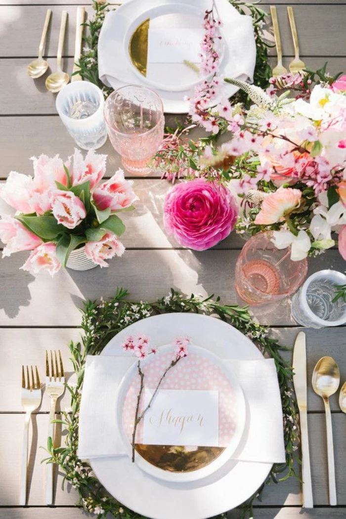 weiße Teller, rosa Servietten, rosa Blumen, auf einem Tisch aus Holz, bunte Tassen, Ideen für 60 Geburtstag