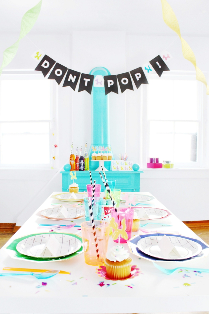 schwarze Girlande mit weißen Buchstaben, bunte Teller und Becher, Cupcakes, Ideen für 60. Geburtstag