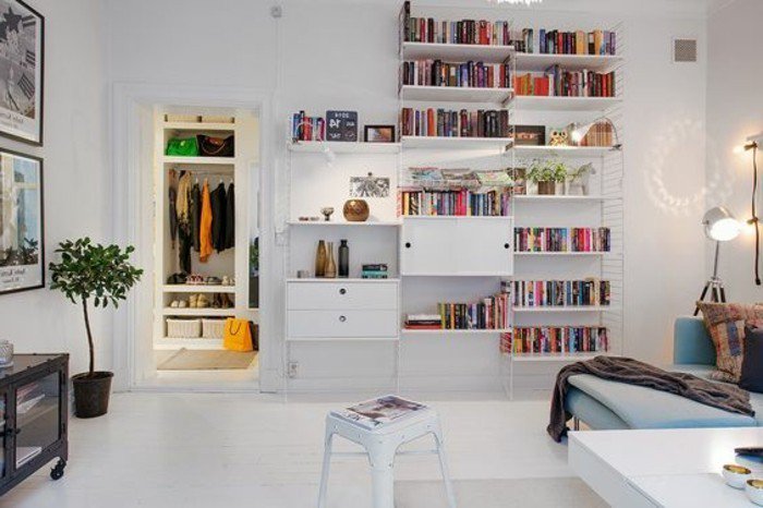 weißer Fliesenboden. weißes Regal mit bunten Büchern, eine Garderobe, Wohnzimmer Ideen für kleine Räume