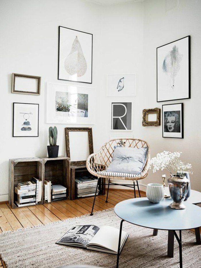 blauer runder Tisch, ein rustikaler Sessel mit blauem Kissen, viele Bilder, Wohnzimmer Ideen für kleine Räume