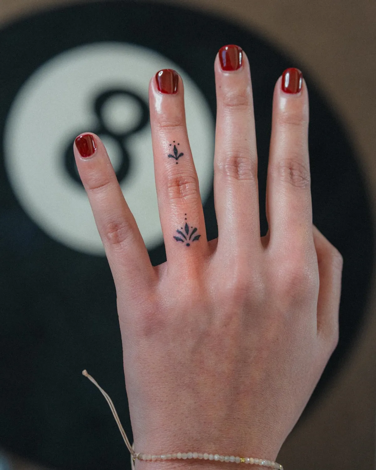 dotwork kleines tattoo am finger mit lotos