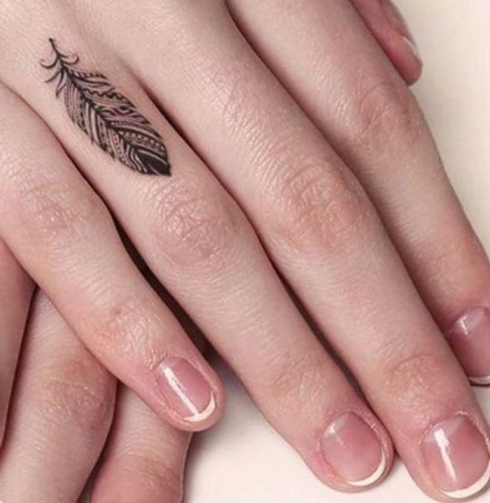 tattoo ideen auf dem finger, ringfinger, eine feine hand von einer frau, french nägel, federtattoo