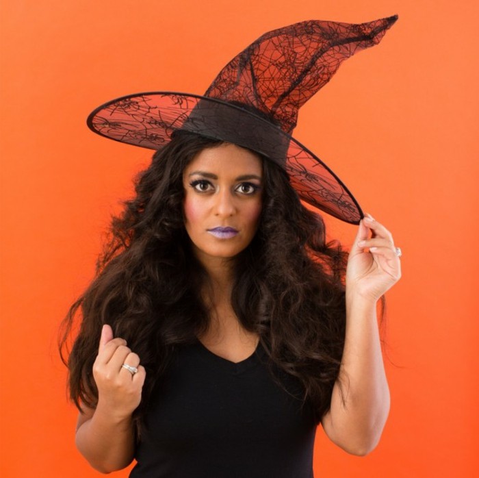 kostüme halloween, eine der populärsten ideen für frauen ist der look von einer hexe, orangen farbe hintergrund